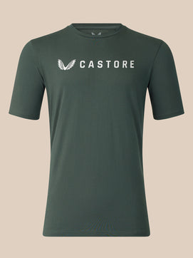 A dark green crewneck t-shirt with a white Castore logo printed on the chest, displayed against a solid beige background.