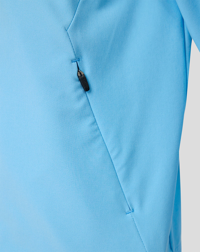 Side view of the light blue Feyenoord junior jacket featuring a zip pocket and stitching.